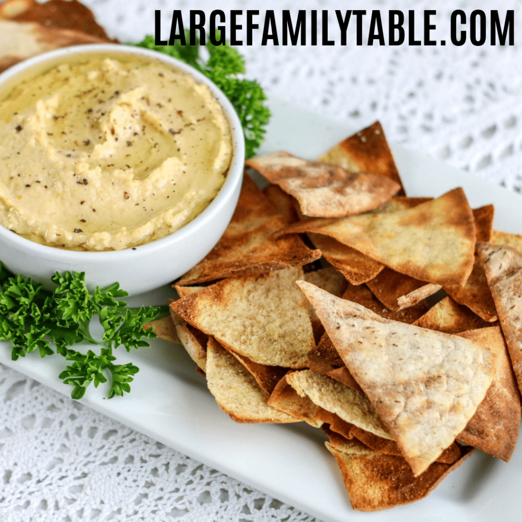 pita chips on a tray with homemade hummus
